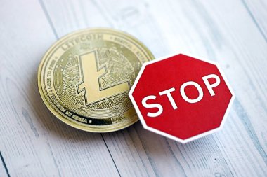 KYIV, UKRAINE - 17 AĞUSTOS 2024 Litecoin LTC madeni para ve kırmızı kağıt dur işareti