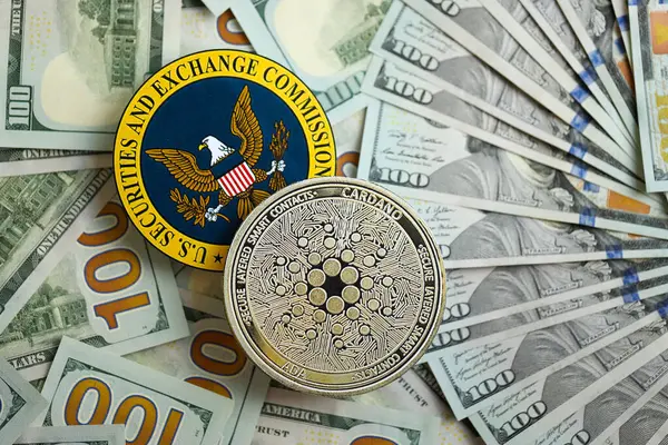 Stock image KYIV, UKRAINE - AUGUST 17, 2024 Cardano ADA coin and US Securities and Exchange Commission sign on money background close up