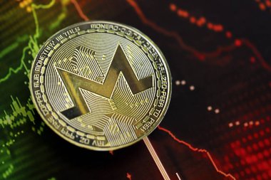 KYIV, UKRAINE - AUGUST 17, 2024 Monero XMR coin on dark cryptocurrency digital trading chart in green and red colors close up clipart