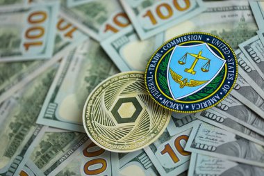 KYIV, UKRAINE - AUGUST 17, 2024 Chainlink LINK coin and US Federal Trade Commission sign on many USD dollar money bills close up clipart