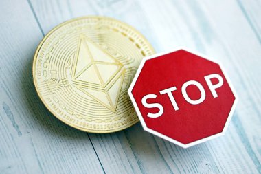 KYIV, UKRAINE - 17 Ağustos 2024 Ethereum ETH madeni para ve kırmızı kağıt dur işareti ahşap arka planda yakın plan