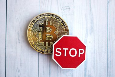 KYIV, UKRAINE - 17 AĞUSTOS 2024 Bitcoin BTC madeni para ve kırmızı kağıt dur işareti ahşap arka planda yakın plan