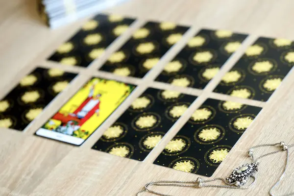 stock image KYIV, UKRAINE - JULY 10, 2024 Tarot minor and major arcana cards of Rider Waite esoteric deck and vintage brooch with female silhouette. Many tarot cards for fortune telling and old amulet close up