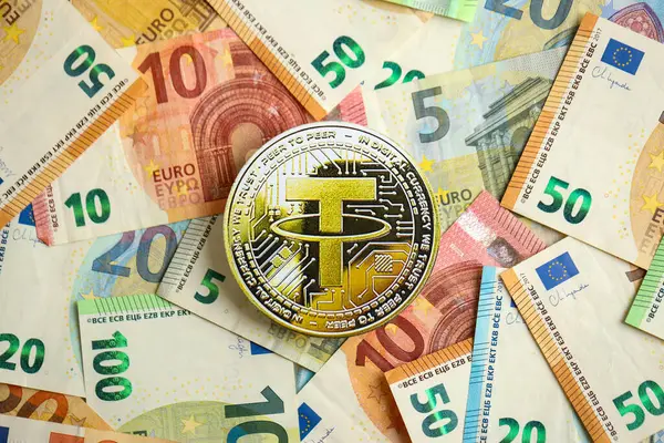 stock image KYIV, UKRAINE - AUGUST 17, 2024 Tether USDT coin with big amount of european euro bills close up