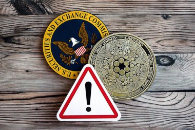 KYIV, UKRAINE - AUGUST 17, 2024 Cardano ADA coin and red paper attention sign with Securities and Exchange Commission on wooden background close up clipart