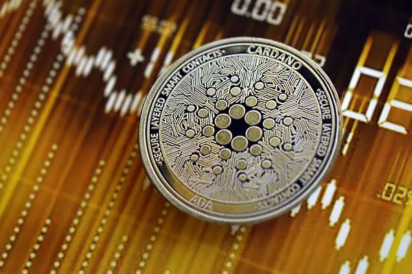 KYIV, UKRAINE - 17 Ağustos 2024 Cardano ADA Koyu kripto para birimi dijital ticaret şeması üzerinde altın sarısı renklerde yakın plan