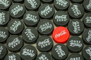KYIV, UKRAINE - 29 Ocak 2025 Coca Cola Plastik şişe kapağı arka plan. Kapak malzemesi geri dönüştürülebilir. Plastik şişelerin kapaklarını geri dönüşümden önce çıkar.