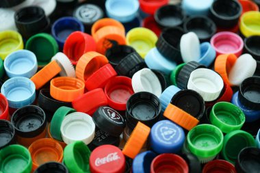 KYIV, UKRAINE - 29 Ocak, 2025 Plastik şişe kapağı arka plan. Kapak malzemesi geri dönüştürülebilir. Plastik şişelerin kapaklarını geri dönüşümden önce çıkar.