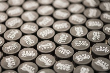 KYIV, UKRAINE - 29 Ocak 2025 Coca Cola Plastik şişe kapağı arka plan. Kapak malzemesi geri dönüştürülebilir. Plastik şişelerin kapaklarını geri dönüşümden önce çıkar.