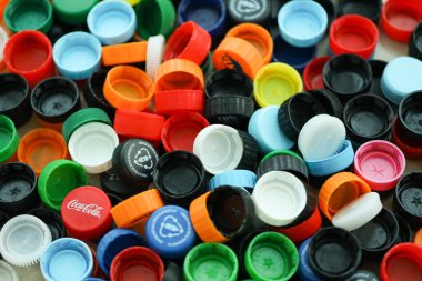 KYIV, UKRAINE - 29 Ocak, 2025 Plastik şişe kapağı arka plan. Kapak malzemesi geri dönüştürülebilir. Plastik şişelerin kapaklarını geri dönüşümden önce çıkar.