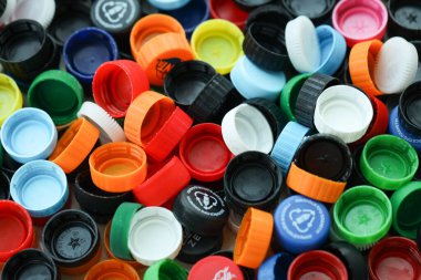 KYIV, UKRAINE - 29 Ocak, 2025 Plastik şişe kapağı arka plan. Kapak malzemesi geri dönüştürülebilir. Plastik şişelerin kapaklarını geri dönüşümden önce çıkar.