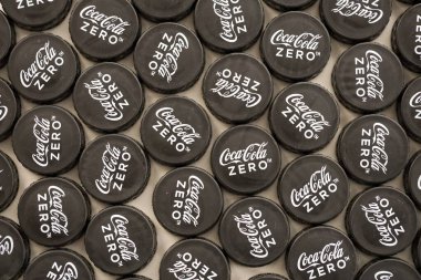 KYIV, UKRAINE - 29 Ocak 2025 Coca Cola Plastik şişe kapağı arka plan. Kapak malzemesi geri dönüştürülebilir. Plastik şişelerin kapaklarını geri dönüşümden önce çıkar.