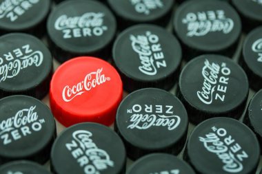 KYIV, UKRAINE - 29 Ocak 2025 Coca Cola Plastik şişe kapağı arka plan. Kapak malzemesi geri dönüştürülebilir. Plastik şişelerin kapaklarını geri dönüşümden önce çıkar.