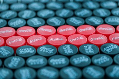 KYIV, UKRAINE - 29 Ocak 2025 Coca Cola Plastik şişe kapağı arka plan. Kapak malzemesi geri dönüştürülebilir. Plastik şişelerin kapaklarını geri dönüşümden önce çıkar.