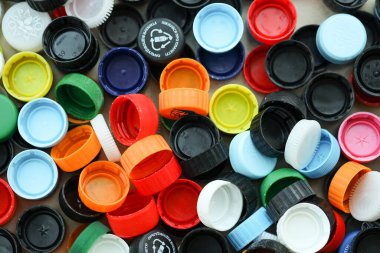 KYIV, UKRAINE - 29 Ocak, 2025 Plastik şişe kapağı arka plan. Kapak malzemesi geri dönüştürülebilir. Plastik şişelerin kapaklarını geri dönüşümden önce çıkar.