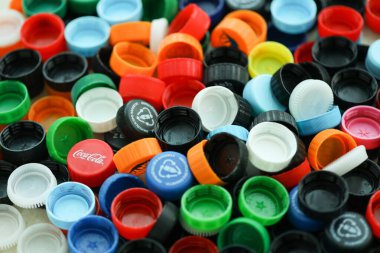 KYIV, UKRAINE - 29 Ocak, 2025 Plastik şişe kapağı arka plan. Kapak malzemesi geri dönüştürülebilir. Plastik şişelerin kapaklarını geri dönüşümden önce çıkar.