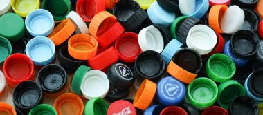 KYIV, UKRAINE - 29 Ocak, 2025 Plastik şişe kapağı arka plan. Kapak malzemesi geri dönüştürülebilir. Plastik şişelerin kapaklarını geri dönüşümden önce çıkar.