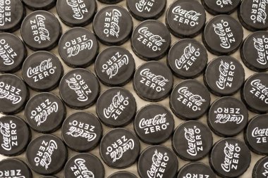 KYIV, UKRAINE - 29 Ocak 2025 Coca Cola Plastik şişe kapağı arka plan. Kapak malzemesi geri dönüştürülebilir. Plastik şişelerin kapaklarını geri dönüşümden önce çıkar.