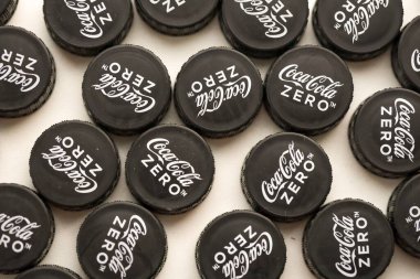 KYIV, UKRAINE - 29 Ocak 2025 Coca Cola Plastik şişe kapağı arka plan. Kapak malzemesi geri dönüştürülebilir. Plastik şişelerin kapaklarını geri dönüşümden önce çıkar.