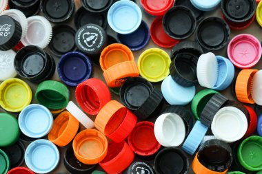 KYIV, UKRAINE - 29 Ocak, 2025 Plastik şişe kapağı arka plan. Kapak malzemesi geri dönüştürülebilir. Plastik şişelerin kapaklarını geri dönüşümden önce çıkar.