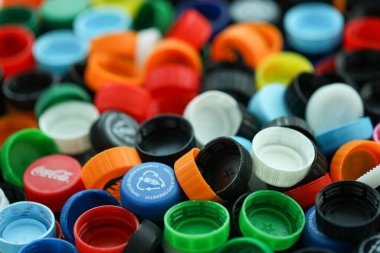 KYIV, UKRAINE - 29 Ocak, 2025 Plastik şişe kapağı arka plan. Kapak malzemesi geri dönüştürülebilir. Plastik şişelerin kapaklarını geri dönüşümden önce çıkar.