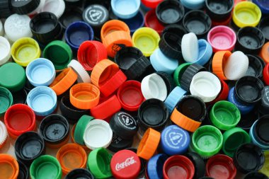 KYIV, UKRAINE - 29 Ocak, 2025 Plastik şişe kapağı arka plan. Kapak malzemesi geri dönüştürülebilir. Plastik şişelerin kapaklarını geri dönüşümden önce çıkar.