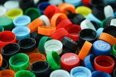 KYIV, UKRAINE - 29 Ocak, 2025 Plastik şişe kapağı arka plan. Kapak malzemesi geri dönüştürülebilir. Plastik şişelerin kapaklarını geri dönüşümden önce çıkar.