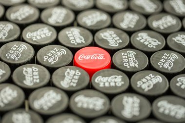 KYIV, UKRAINE - 29 Ocak 2025 Coca Cola Plastik şişe kapağı arka plan. Kapak malzemesi geri dönüştürülebilir. Plastik şişelerin kapaklarını geri dönüşümden önce çıkar.