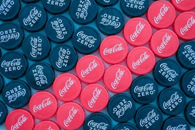 KYIV, UKRAINE - 29 Ocak 2025 Coca Cola Plastik şişe kapağı arka plan. Kapak malzemesi geri dönüştürülebilir. Plastik şişelerin kapaklarını geri dönüşümden önce çıkar.