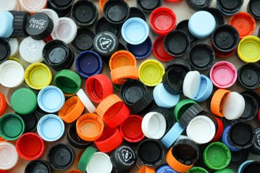 KYIV, UKRAINE - 29 Ocak, 2025 Plastik şişe kapağı arka plan. Kapak malzemesi geri dönüştürülebilir. Plastik şişelerin kapaklarını geri dönüşümden önce çıkar.