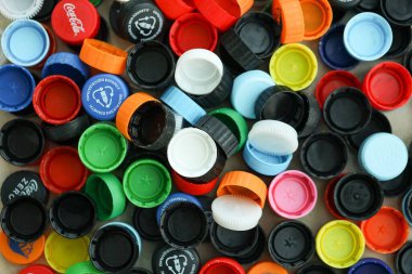 KYIV, UKRAINE - 29 Ocak, 2025 Plastik şişe kapağı arka plan. Kapak malzemesi geri dönüştürülebilir. Plastik şişelerin kapaklarını geri dönüşümden önce çıkar.