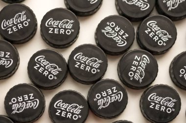 KYIV, UKRAINE - 29 Ocak 2025 Coca Cola Plastik şişe kapağı arka plan. Kapak malzemesi geri dönüştürülebilir. Plastik şişelerin kapaklarını geri dönüşümden önce çıkar.