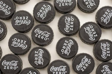 KYIV, UKRAINE - 29 Ocak 2025 Coca Cola Plastik şişe kapağı arka plan. Kapak malzemesi geri dönüştürülebilir. Plastik şişelerin kapaklarını geri dönüşümden önce çıkar.