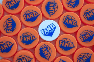 KYIV, UKRAINE - 29 Ocak 2025 Fanta Plastik şişe kapağı arka planı. Kapak malzemesi geri dönüştürülebilir. Plastik şişelerin kapaklarını geri dönüşümden önce çıkar.