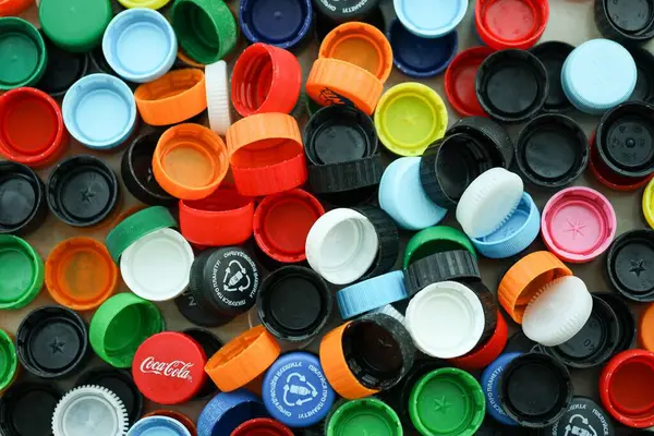 KYIV, UKRAINE - 29 Ocak, 2025 Plastik şişe kapağı arka plan. Kapak malzemesi geri dönüştürülebilir. Plastik şişelerin kapaklarını geri dönüşümden önce çıkar.