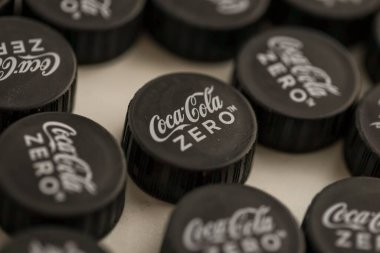 KYIV, UKRAINE - 29 Ocak 2025 Coca Cola Plastik şişe kapağı arka plan. Kapak malzemesi geri dönüştürülebilir. Plastik şişelerin kapaklarını geri dönüşümden önce çıkar.