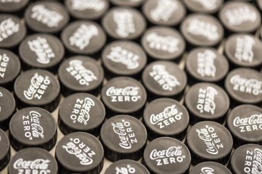 KYIV, UKRAINE - 29 Ocak 2025 Coca Cola Plastik şişe kapağı arka plan. Kapak malzemesi geri dönüştürülebilir. Plastik şişelerin kapaklarını geri dönüşümden önce çıkar.