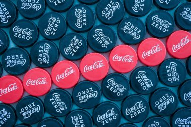 KYIV, UKRAINE - 29 Ocak 2025 Coca Cola Plastik şişe kapağı arka plan. Kapak malzemesi geri dönüştürülebilir. Plastik şişelerin kapaklarını geri dönüşümden önce çıkar.