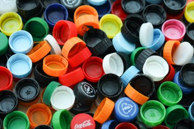 KYIV, UKRAINE - 29 Ocak, 2025 Plastik şişe kapağı arka plan. Kapak malzemesi geri dönüştürülebilir. Plastik şişelerin kapaklarını geri dönüşümden önce çıkar.