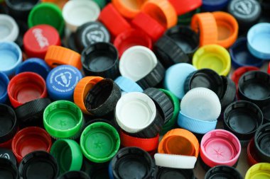 KYIV, UKRAINE - 29 Ocak, 2025 Plastik şişe kapağı arka plan. Kapak malzemesi geri dönüştürülebilir. Plastik şişelerin kapaklarını geri dönüşümden önce çıkar.