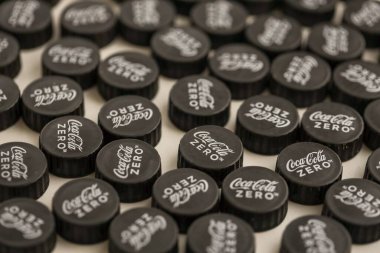 KYIV, UKRAINE - 29 Ocak 2025 Coca Cola Plastik şişe kapağı arka plan. Kapak malzemesi geri dönüştürülebilir. Plastik şişelerin kapaklarını geri dönüşümden önce çıkar.