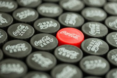 KYIV, UKRAINE - 29 Ocak 2025 Coca Cola Plastik şişe kapağı arka plan. Kapak malzemesi geri dönüştürülebilir. Plastik şişelerin kapaklarını geri dönüşümden önce çıkar.