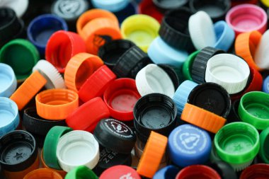 KYIV, UKRAINE - 29 Ocak, 2025 Plastik şişe kapağı arka plan. Kapak malzemesi geri dönüştürülebilir. Plastik şişelerin kapaklarını geri dönüşümden önce çıkar.