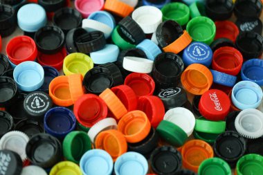KYIV, UKRAINE - 29 Ocak, 2025 Plastik şişe kapağı arka plan. Kapak malzemesi geri dönüştürülebilir. Plastik şişelerin kapaklarını geri dönüşümden önce çıkar.