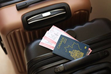 Biletli Kanada pasaportu havaalanı bekleme salonundaki turistik bavulun üzerinde yatıyor. Dünya çapında seyahat ve uluslararası turizm kavramı