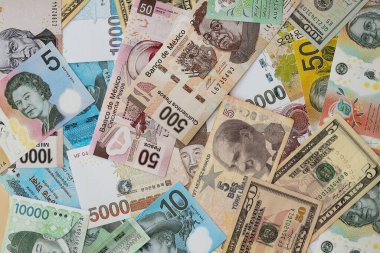 Farklı para birimlerinden ve ülkelerden yüklü miktarda para. Uluslararası nakitin çeşitli arka planında büyük bir yığın var.