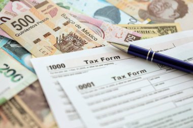 Değişik para birimlerinden ve ülkelerden oluşan büyük miktarlarda para ve vergi beyannamesi doldurulmaya hazır. Uluslararası nakitin çeşitli arka planında büyük bir yığın var.