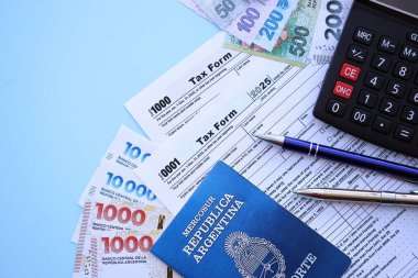 Arjantin Pezosu 'nun para faturaları kalem, hesap makinesi, pasaport ve vergi formlarıyla dolu. Finans ve bankacılık kavramı