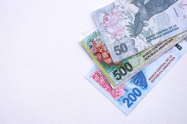 Arjantin pezosu büyük miktarlarda para beyaz masada yakın planda yatıyor. Finans ve bankacılık kavramı
