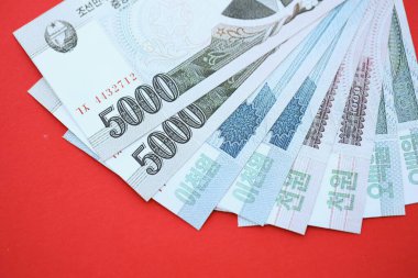 Kuzey Kore büyük miktarlarda para kazandı. Yakın plan kırmızı masada yatıyor. Finans ve bankacılık kavramı